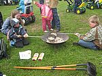 Kinder machen Poppkorn am Feuer
